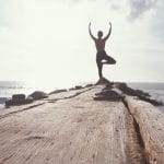 Woman posed for yoga at end of dock Financial Strategies Group blog
