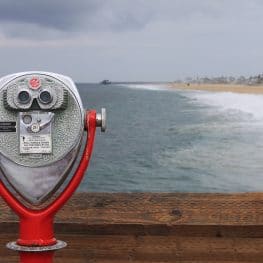 Picture of viewfinder on boardwalk looking out to the beach on a cloudy day.